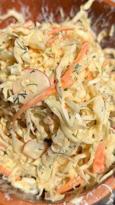 a wooden bowl filled with coleslaw and carrots