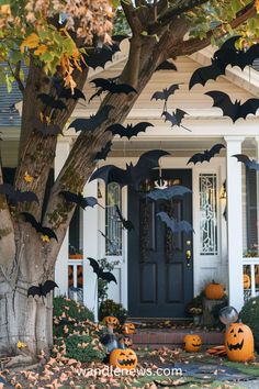 halloween decorations in front of a house with bats