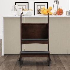 a wooden chair sitting on top of a hard wood floor next to a kitchen counter