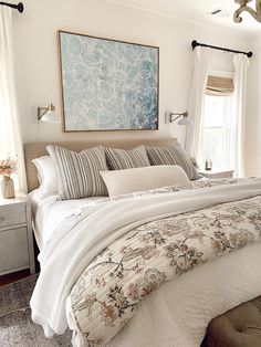 a large bed sitting in a bedroom next to a window