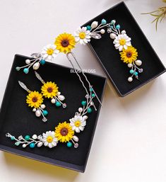 two black trays with yellow and white flowers on them, one is holding a pair of scissors