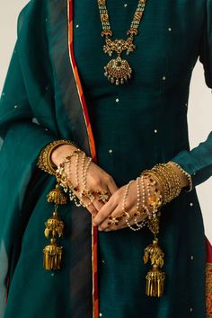 a woman wearing green and gold jewelry