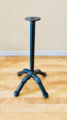 a black tripod sitting on top of a hard wood floor