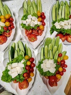 four plates filled with different types of vegetables and cheese on top of each plate,