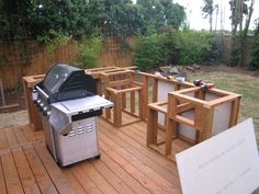 an outdoor bbq grill sitting on top of a wooden deck