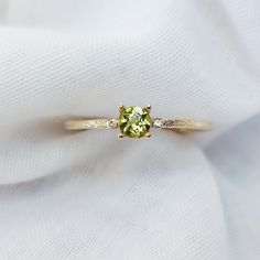 "Solid Gold Peridot Ring With Diamond/ Peridot Engagement Ring/ Promise Ring For Women/ August Birthstone Ring, Textured Round Peridot Ring  Beautiful 9K gold textured band, peridot and diamond engagement ring. The ring features a round 4mm peridot set in a 4 claw prong setting.  Materials: Solid 9ct yellow gold Gemstone: 4mm Peridot Band Width:  1.2mm  Photos of this ring have been taken close up for detail. Please refer to a ruler for dimensions of stone and band width. Don't forget to hit \"favourite\" on the right, so it remains in your favourites list and/ or add to your wish list(s). ------------------------------------------------------------------------------------------------------------------------------------------ Want to find out more? check out our shop https://www.etsy.com/u Peridot Diamond Ring, Yellow Gold Peridot Rings With Gemstone Accents, Green Sapphire Ring With Accent Stones For Promise, Green Sapphire Promise Ring With Accent Stones, Wedding Ring With Yellow Sapphire And Gemstone Accents, Elegant Lime Green Gemstone Rings, Green Diamond Birthstone Ring With Round Band, Yellow Gold Peridot Diamond Ring, Gold Yellow Sapphire Rings With Gemstone Accents