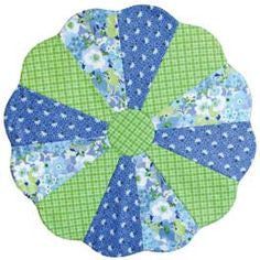 a blue and green flowered patchwork design on a white background, with the center section cut out to look like an umbrella