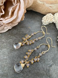 One of a kind gemstone dangle earrings .. crafted with hand forged gold tone accents with delicate gold tone chain and Rose Quartz gemstones accented with hand wire wrapped clear Quartz gemstones . These sweet beauties measure 3.5 inches in length . Gold Dangling Bead Jewelry, Gold Dangling Bead Earrings, Gold Dangle Jewelry With Beads, Gold Dangle Jewelry With Dangling Beads, Gold Wire Wrapped Crystal Earrings For Wedding, Wire Wrapped Drop Chandelier Earrings As Gift, Wire Wrapped Chandelier Drop Earrings For Gift, Gold Briolette Crystal Earrings With Ear Wire, Gold Briolette Crystal Earrings For Wedding