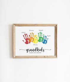 a wooden frame hanging on the wall displaying a handprinted sign that reads grandkids make life great