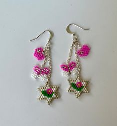 Playful and charming, these earrings feature 4 symbols-- Stars of David for Jewish identity, hearts for love, butterflies for freedom, and flowers for nature. I patiently hand-beaded them using Miyuki Delica beads. Completed with sterling silver ear wires, they are comfortable and secure. They are lightweight and eye-catching.  Enjoy the attention! Length: 2" Whimsical Pink Sterling Silver Jewelry, Pink Dangling Charms Drop Earrings, Pink Star-shaped Sterling Silver Jewelry, Pink Sterling Silver Flower Earrings For Gift, Pink Sterling Silver Heart Dangle Earrings, Pink Drop Earrings With Dangling Charms, Pink Sterling Silver Flower Earrings As Gift, Pink Sterling Silver Heart Earrings Nickel Free, Pink Sterling Silver Flower Earrings Nickel Free