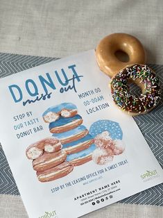 a donut sitting on top of a table next to a poster