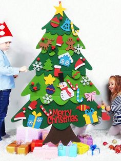 two children are playing around a christmas tree