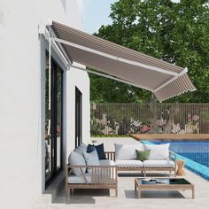 an outdoor living area with couches and tables next to a swimming pool