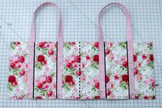 four bags made out of fabric with pink flowers and green leaves on the bottom, one has