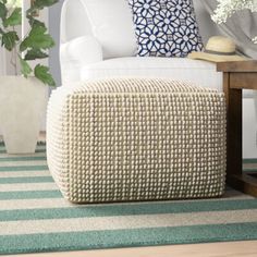 a living room with a white couch and green striped rugs on the floor next to a coffee table