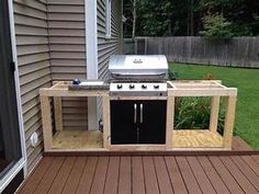 an outdoor bbq grill built into the side of a home's backyard deck