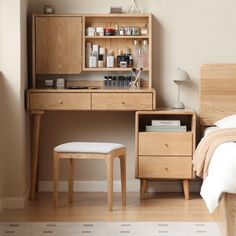 a bed room with a neatly made bed and a wooden dresser next to a mirror