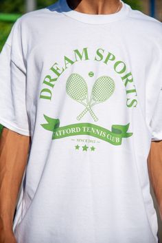 Join the Catford tennis club with our fun addition to the best selling Dream Sports collection. 100% heavyweight cotton t-shirt with front print and back prints Model is 5'11''/ 180cm and wearing a size x-large. Relaxed fit. Order the size you would usually wear. Size up if you are between sizes or would like an oversized fit. For a regular fit: 6/8- small, 10- medium, 12- large, 14- x-large. Free stickers included in every order We have a 30 day no hassle return policy Although we aim to ship all orders the same or next working day, please allow up to 2 working days for your order to be shipped as we make everything to order Washing instructions: 30 wash with similar colours, Reshape while damp, Do not iron print, Tumble dry medium, Do not bleach Cotton Short Sleeve T-shirt For Tennis, Sporty Screen Print T-shirt For Tennis, White Graphic Tennis T-shirt, Green Cotton T-shirt For Tennis, Sporty T-shirt With Team Name For Tennis, Pre-shrunk Cotton Tennis T-shirt, Crew Neck Tennis T-shirt With Letter Print, Casual Tennis T-shirt With Team Name, Cotton Graphic Tee For Tennis