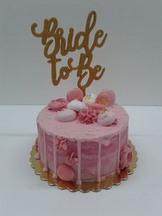 a cake with pink frosting and gold lettering that says bride to be on top