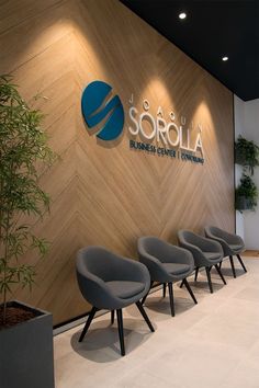 four chairs are lined up in front of a wall with the logo sorolla on it