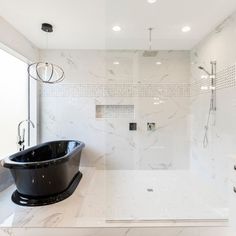 a bath tub sitting in the middle of a bathroom next to a walk in shower