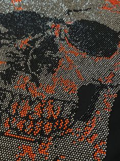 an orange and black pattern on fabric with some sort of design in the middle,