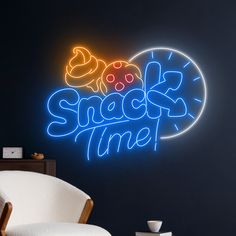 a neon sign that says snacks time on the wall next to a chair and table