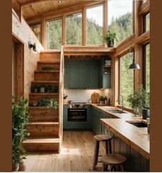 a kitchen with green cabinets and wooden stairs leading up to the upper floor, along with potted plants