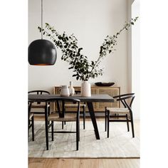 a dining room table and chairs with plants in vases on the top one side