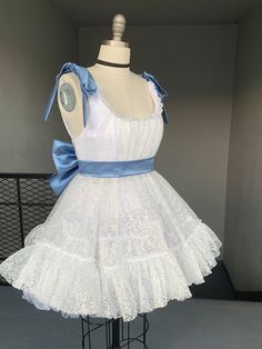 The Marie Dress is a gorgeous, handmade in LA tea dress custom made to your measurements. It's orginal colors are white and powered blue, but the colors can be interchanged to your preference. The dress shown in the photos has a petticoat under to create more fluffiness. Please allow 2-3 weeks for sewing and shipping. Measurements required for custom fit: Bust Underbust Overbust Waist  Strap Length  Skirt Length Coquette Sleeveless Lace Dress, Feminine Lace Dress With Contrast Lace, Feminine Lace Dress With Contrast Details, Fitted Lace Dress With Ruffles And Tulle, Fitted Lace Dress With Ruffles For Garden Party, Fitted Tulle Lace Dress With Ruffles, White Lace Balletcore Dress, White Balletcore Mini Dress With Ruffles, Lace Wedding Dress With Ruffled Straps