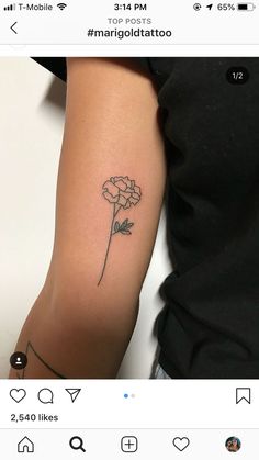 a woman's arm with a small flower tattoo on the left side of her arm