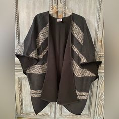 Ladies Black Poncho With Black, Grey, And White Patterned Intermittent Horizontal Stripes. This Poncho Is 33” Long And 45” From Side To Side. There Are Black Frog Closures On Each Side To Keep The Poncho Somewhat Closed. This Poncho Has Never Been Worn/ Used. Black Shawl Poncho One Size, Black Oversized Chic Poncho, One Size Black Casual Cardigan, Black One Size Casual Cardigan, Oversized Black Chic Poncho, Oversized Cozy Black Poncho, Casual Black One Size Cardigan, Oversized Black Cardigan For Cold Weather, Cozy Oversized Black Poncho