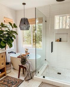 a white bath tub sitting next to a wooden cabinet in a bathroom under a window