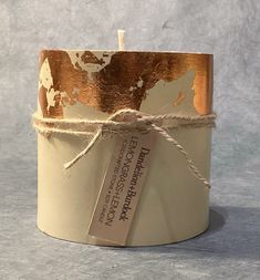 a candle that is wrapped in twine and has a tag on the top of it