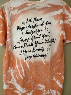 an orange and white tie dye shirt with words written on it