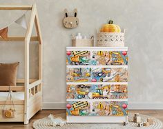 a child's room with a toy truck and construction vehicles on the dresser next to a bed