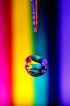 two drops of water are in front of a multicolored background with the same color