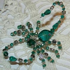 a green beaded snowflake on a lace tablecloth