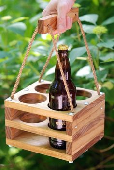 a wooden box with two beer bottles in it and some string hanging from the top