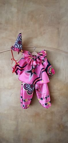 a pink and black outfit hanging on a clothes line with a butterfly attached to it