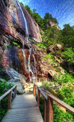 a wooden walkway leading to a waterfall