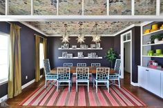 a dining room table with chairs and a rug on the floor in front of it