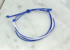 Simple, yet stylish this waxed cord bracelet is 100% waterproof you can shower and swim with it on without taking it off. It is adjustable and fits size 6-11" wrists.  Style Includes: * Blue and White  * Adjustable 6-11" * Handmade in Minnesota   DESIGN YOUR OWN BRACELET: * If you'd like different colors in your bracelet select 'Custom' from the drop-down menu. * In the note to seller box note what colors you'd like  Material: * Polyester Waxed Cord  Bracelets Perfect for: * Everyday Wear * Women, Men and Children * Cancer Awareness * Fundraisers * Ride/Run for a cause     Check out other colors here: https://www.etsy.com/shop/FlyingBirdJewelry?ref=hdr_shop_menu&section_id=21527702 INTERNATIONAL ORDERS: * International orders are taking over a month and a half to arrive at its destination. Waxed Cord Bracelets, Friendship Bracelet String, Wax Cord Bracelet, Bracelet String, Bracelet Cord, Handmade Friendship Bracelets, Bracelet Friendship, White Wax, Cord Bracelet