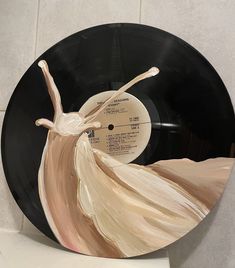 a vinyl record with a painting of a woman in a flowing dress on the side