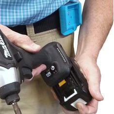 a man holding a cordless driller in his hands