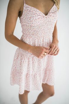 Elevate your look with our Dylan mini dress, a perfect blend of elegance and summer fun. This dress features a flattering twist front design and playful tiered layers. It has adjustable spaghetti straps that ensure a personalized fit, while the smocked back provides comfortable stretch and support. Ideal for both casual outings and special occasions, this mini dress is your go-to choice for a chic and effortless look. Size Chart Features: mini length twist front v-neck design smocking adjustable spaghetti straps lined fabric content: 100% polyester model is wearing a small. Height 5'7" Bust 34", Waist 25", Hip 36" Fitted Tiered Mini Dress With Smocked Back, Fitted Mini Dress With Smocked Back And Tiered Design, Smocked Bodice Sundress With Spaghetti Straps, Fitted Tiered Smocked Sundress, Trendy Spaghetti Straps Dresses For Garden Party, Fitted Smocked Sundress With Tiered Skirt, Flirty Tiered Mini Dress With Smocked Bodice, Feminine Tiered Ruched Mini Dress, Brunch Sundress With Smocked Back