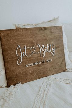 a wooden sign sitting on top of a bed