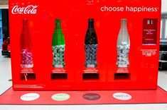 coca - cola bottles are displayed in a display case