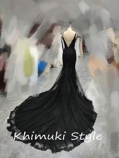 the back of a black dress on display in front of an abstract background with text that reads