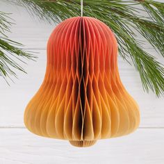 an ornament hanging from a pine tree with red and yellow paper folded in the shape of a pear